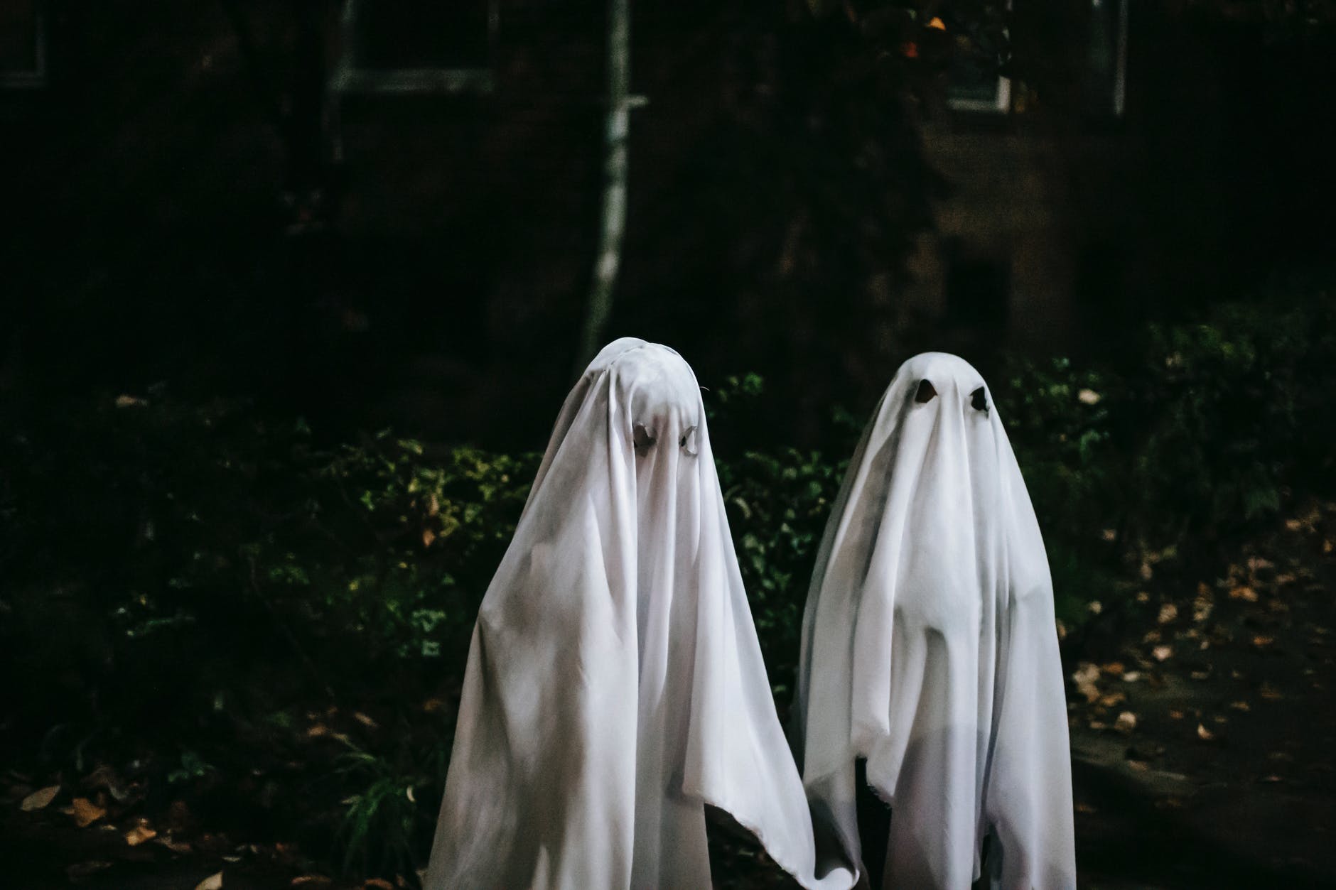 unrecognizable children in ghost costumes in town